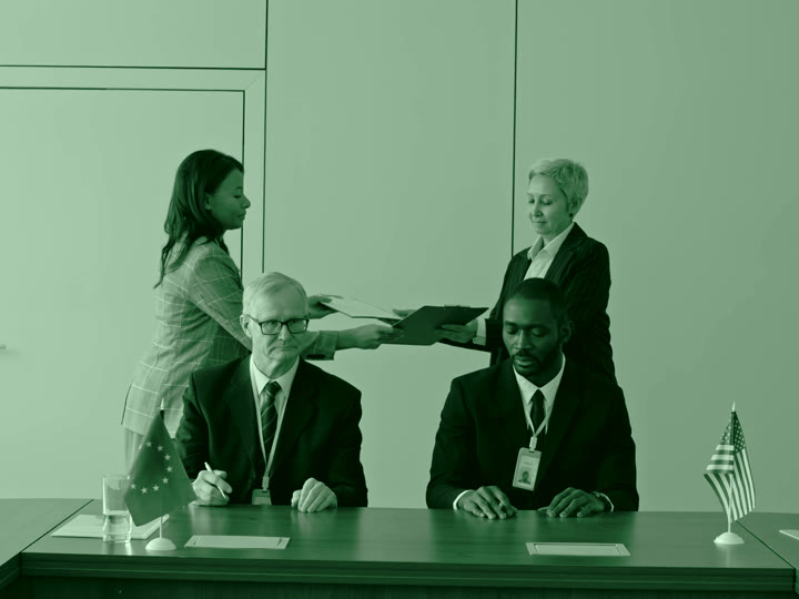 Business documents being handed across an office table