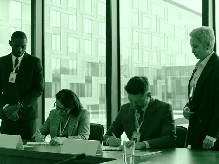 Two business partners signing their completed agreement